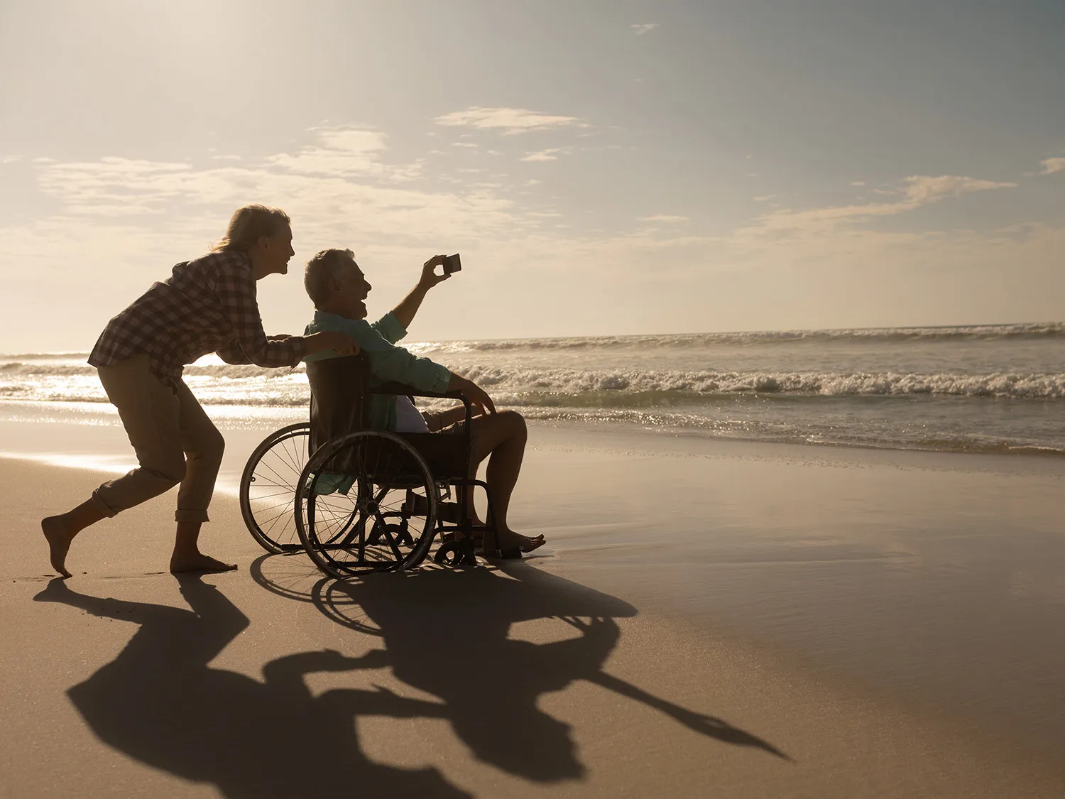 woman pushing a man in wheelchair