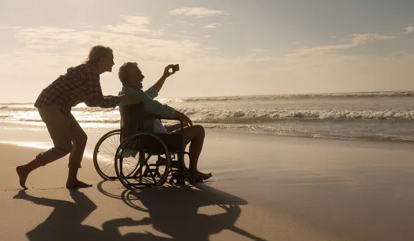 woman pushing a man in a wheelchair