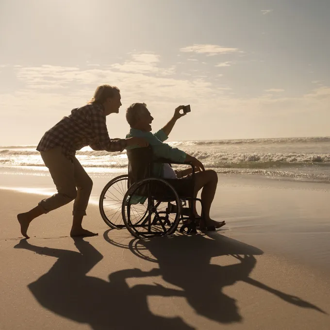 woman pushing a man in wheelchair